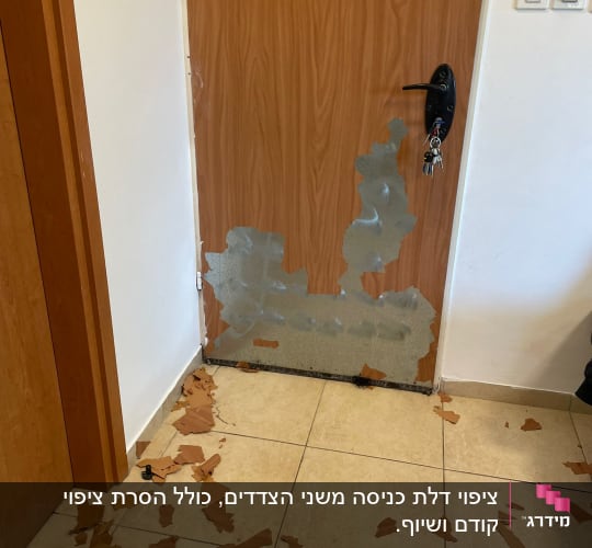 דלת עם ציפוי מתקלף וחתיכות על הרצפה